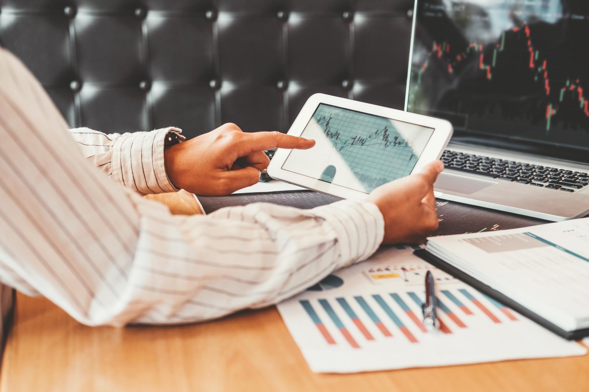 Investor reviewing stock charts on a tablet